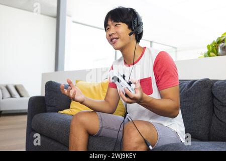 Teenager asiatischer Junge spielt zu Hause gerne mit Kopierraum Stockfoto