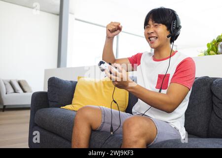 Teenager asiatischer Junge spielt zu Hause gerne mit Kopierraum Stockfoto