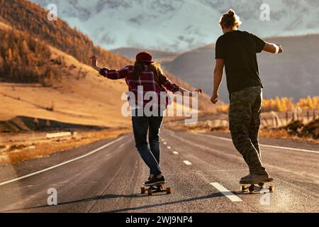 Junge Hipster trainieren auf Longboards auf der Sunset Mountain Road Stockfoto