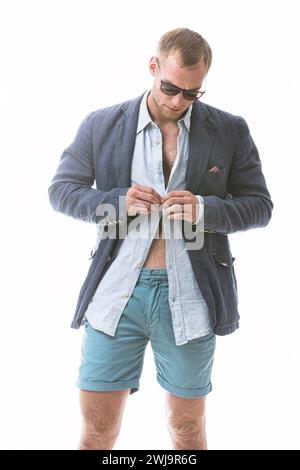 Mode, Knopf und Mann im Studio mit Kleidung, trendigem Blazer, stilvollem Outfit für eine coole Ästhetik. Tragen, Selbstvertrauen oder männliches Model mit einem Fancy Stockfoto