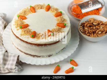 Hausgemachte Karottenkuchen mit Walnüssen, geeist mit Frischkäse. Süßes Dessert. Teller mit köstlichem Karottenkuchen Stockfoto