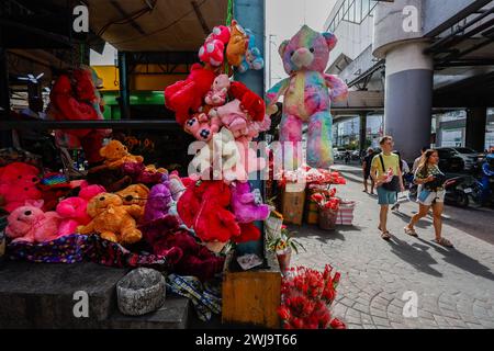 Manila, Manila, Die Philippinen. Februar 2024. Ein paar spazieren an einem Laden vorbei, in dem Teddybären und Blumen verkauft werden, am Valentinstag. Lokale Medien sagen, dass das Festival wirtschaftliche Vorteile für das Land bringen wird, da die Menschen mehr Geld für den Kauf von Blumen, Schokolade und anderen Geschenken ausgeben, um ihr Engagement und ihre Liebe zu ihren Partnern zu zeigen. (Kreditbild: © Daniel Ceng Shou-Yi/ZUMA Press Wire) NUR REDAKTIONELLE VERWENDUNG! Nicht für kommerzielle ZWECKE! Stockfoto