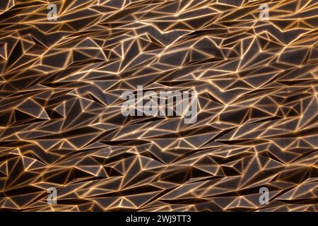 Abstrakter Hintergrund in Form einer zerknitterten Goldfolie. Eine Wand mit einer originalen Textur aus Gips und in goldenen Tönen bemalt. Stockfoto