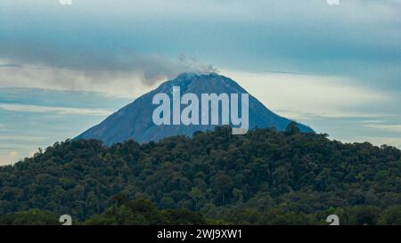 Aus der Vogelperspektive des aktiven Stratovulkans Sinabung, bedeckt mit Wolken. Sumatra, Indonesien. Stockfoto
