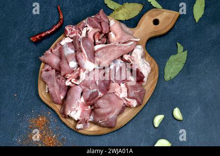 Schweinefleisch in Stücke geschnitten liegt auf einem Schneidebrett, von oben. Stockfoto