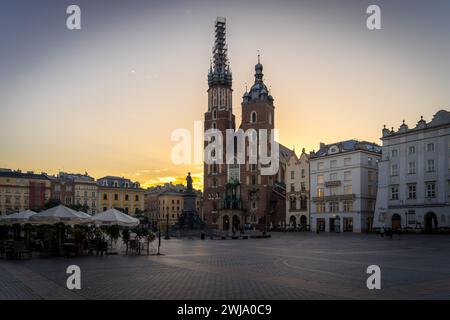 Krakau, Polen - 13. August 2023: Hauptmarktplatz in Kraków mit der St. Marias Kathedrale am frühen Morgen, mit sehr wenigen Leuten. Krakauer Tapete. Stockfoto