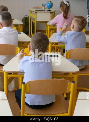 Schüler der jüngeren Klasse hören in der Schule einen Geographiestunden Stockfoto