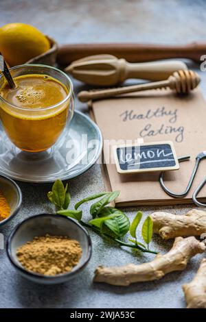 Ein köstlicher goldener Kurkuma-Tee, Zutaten und gesundes Esskonzept auf einem rustikalen Tisch Stockfoto