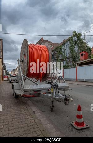 Lichtwellenleiter-Kabeltrommel auf einem Anhänger am Straßenrand Stockfoto