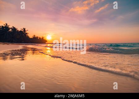 Fantastischer Blick aus der Nähe auf die ruhigen Meerwasserwellen mit orangefarbenem Sonnenaufgang Sonnenuntergang. Tropische Inselstrandlandschaft, exotische Küste. Sommerurlaub Stockfoto