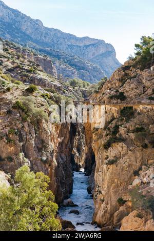 Der Caminito del Rey-Pfad überquert eine bergige Schlucht mit einem Fluss darunter und Wanderer auf dem Weg Stockfoto