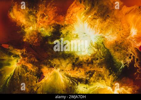 Eine fesselnde abstrakte Darstellung einer feurigen Explosion mit einer Mischung aus leuchtenden Rot-, Gelb-, Orange- und Grüntönen in einem fließenden Kunstgemälde Stockfoto