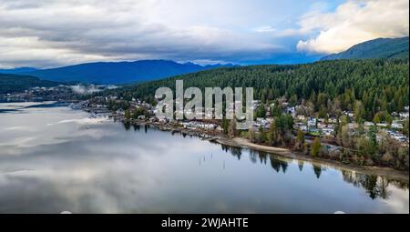 Malerische Häuser am See eingebettet zwischen üppigen Bäumen und majestätischen Bergen. Vancouver, BC, Kanada. Stockfoto