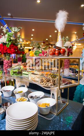 Genießen Sie eine köstliche Auswahl an Salaten, Gemüse und Snacks, die kunstvoll auf einem Buffet-Tisch präsentiert werden. Perfekt für Veranstaltungen, Partys oder Versammlungen. Iso Stockfoto