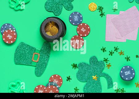 Pokerchips, Topf mit Münzen, Karten und Klee auf grünem Hintergrund. St. Patrick's Day-Feier Stockfoto