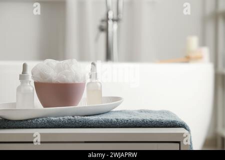 Kosmetikflaschen mit Luffa auf dem Tisch im Badezimmer, Nahaufnahme Stockfoto