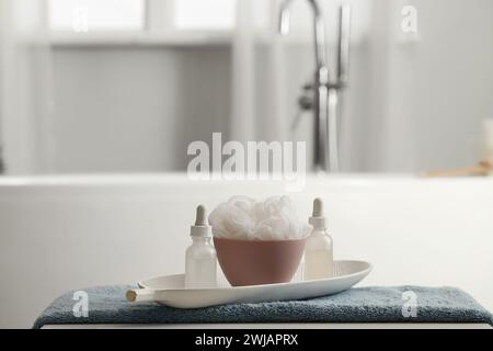 Kosmetikflaschen mit Luffa auf dem Tisch im Badezimmer, Nahaufnahme Stockfoto