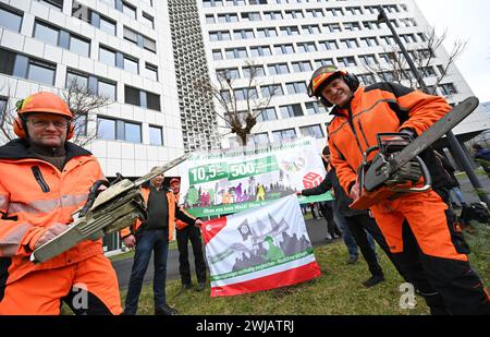 Wiesbaden, Deutschland. Februar 2024. Mitarbeiter von Hessen Forst stehen mit Kettensägen vor dem Innenministerium während einer Demonstration von Mitarbeitern des öffentlichen Dienstes in Hessen zu Beginn der Tarifverhandlungen. Für alle anderen bundesländer ist bereits eine Tarifvereinbarung erzielt worden - jetzt beginnen auch in Hessen die Gespräche über mehr Geld für Staatsangestellte. Etwa 45.000 Menschen sind betroffen. Vermerk: Arne Dedert/dpa/Alamy Live News Stockfoto