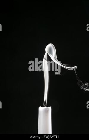 Rauch einer erloschenen Kerze, Nahaufnahme, vor schwarzem Hintergrund gesehen Stockfoto