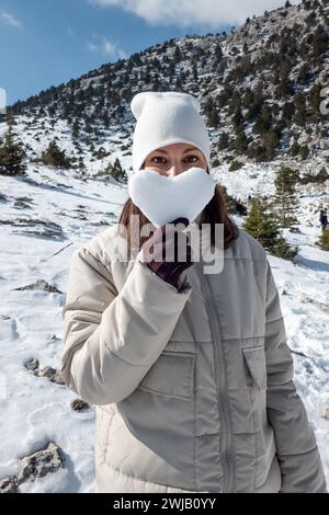 Porträt einer Frau, die ein herzförmiges Eisstück hält Stockfoto