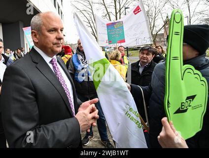 Wiesbaden, Deutschland. Februar 2024. Der hessische Innenminister Roman Poseck (CDU, l) spricht vor dem Innenministerium zu Beginn von Tarifverhandlungen mit Beschäftigten des öffentlichen Dienstes in Hessen. Für alle anderen bundesländer ist bereits eine Tarifvereinbarung erzielt worden - jetzt beginnen auch in Hessen Gespräche über mehr Geld für die Landesangestellten. Etwa 45.000 Menschen sind betroffen. Vermerk: Arne Dedert/dpa/Alamy Live News Stockfoto