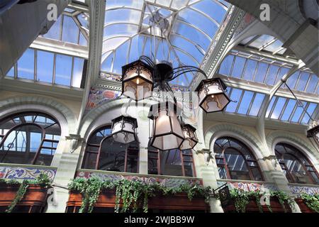 Blick auf die Lampenschirme im Jugendstil, die vom Glas- und Holzdach der Royal Arcade, Norwich, hängen. Stockfoto