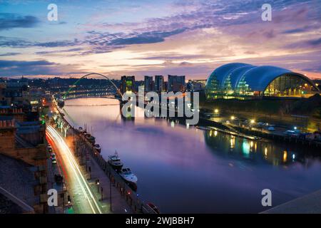 Millennium Bridge über den Fluss Tyne mit Sonnenaufgang am frühen Morgen. Glashaus am South Quay und Lichtwege am North Quay. Stockfoto