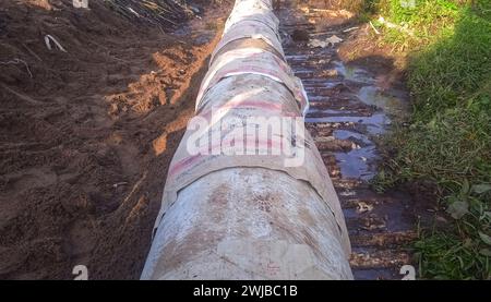 Verlegung eines Kanalbeton-Abflussrohrs zwischen großen Wohngebieten Stockfoto