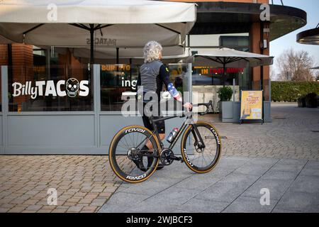 Novara, Italien, 16. Januar 2024: Ein Radfahrer, der ein Fahrrad schiebt, verlässt das Einkaufszentrum „Vicolungo the Style Outlets“ Stockfoto