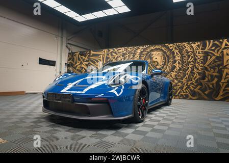 Blauer Porsche 911 GT3 mit Racing Stripes in künstlerischer Industriegarage Stockfoto