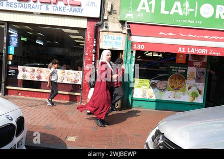 Frau im Hijab spaziert im multikulturellen Bury Park von Luton im Südosten Großbritanniens Stockfoto