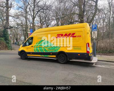 Elektrischer Lieferwagen des Logistikunternehmens DHL in einer Straße in den Haag, Niederlande Stockfoto