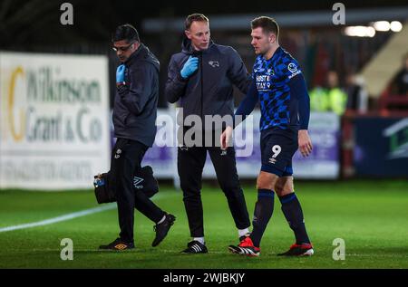 James Collins von Derby County (rechts) mit dem Chief Medical Officer Amit Pannu (links) und dem Head Physiotherapeuten John Hartley während des Spiels der Sky Bet League One im St James Park, Exeter. Bilddatum: Dienstag, 13. Februar 2024. Stockfoto