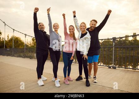 Freunde, die lächeln und Hände heben im City Park Stockfoto