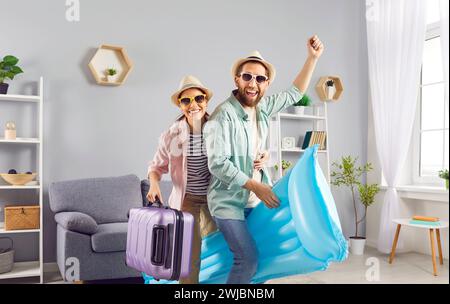 Glückliches junges Paar, das Spaß hat, bereit für einen Sommerurlaub zu Hause zu stehen. Stockfoto