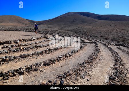 Mann besucht Wolf Pattons Labyrinth - niedriges Steinlabyrinth mitten im Nirgendwo in der Nähe von El Cotillo, Fuerteventura. Vom November 2023 Stockfoto