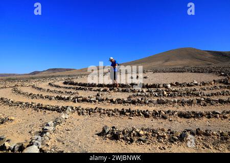 Mann besucht Wolf Pattons Labyrinth - niedriges Steinlabyrinth mitten im Nirgendwo in der Nähe von El Cotillo, Fuerteventura. Vom November 2023 Stockfoto