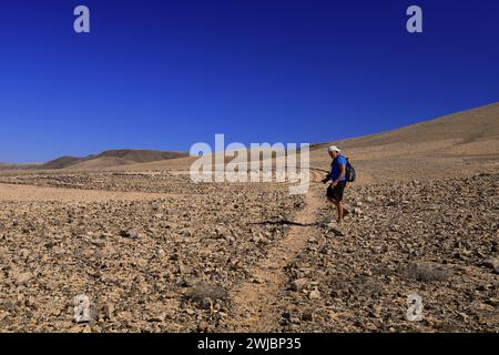 Mann besucht Wolf Pattons Labyrinth - niedriges Steinlabyrinth mitten im Nirgendwo in der Nähe von El Cotillo, Fuerteventura. Vom November 2023 Stockfoto