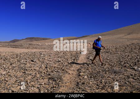 Mann besucht Wolf Pattons Labyrinth - niedriges Steinlabyrinth mitten im Nirgendwo in der Nähe von El Cotillo, Fuerteventura. Vom November 2023 Stockfoto