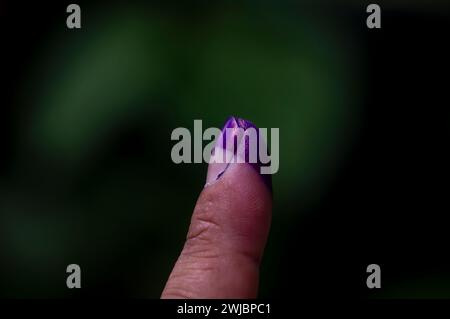 Ein mit blauer Tinte befleckter Finger zeigt, dass ein Bewohner an der Wahl eines neuen Präsidenten in Indonesien beteiligt war. Stockfoto