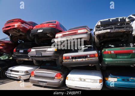 Mehrere Autos auf dem Schrott-Recycling-Schrottplatz gestapelt. Stockfoto