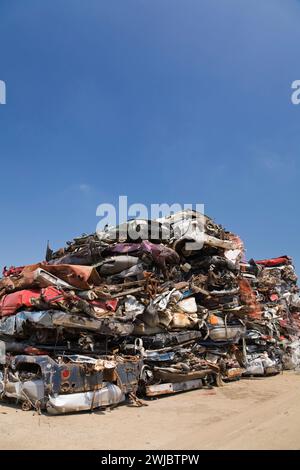 Zerquetschte und gestapelte ausrangierte Autos auf der Altmetallrecyclinganlage. Stockfoto