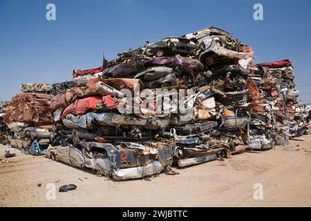 Zerquetschte und gestapelte ausrangierte Autos auf der Altmetallrecyclinganlage. Stockfoto