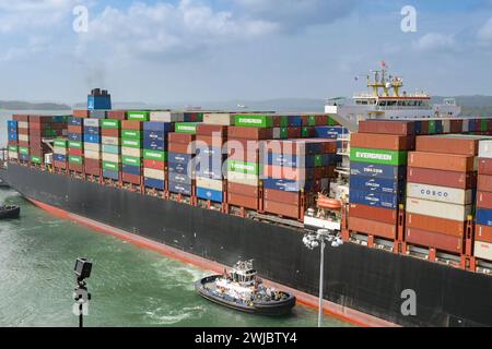 Colon, Panama - 22. Januar 2024: Schlepper, die einem großen Containerschiff bei der Durchfahrt der Schleusen der Agua Clara auf dem Panamakanal helfen Stockfoto