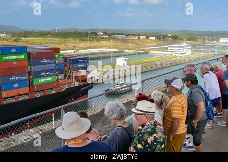 Colon, Panama - 22. Januar 2024: Menschen auf der Aussichtsplattform des Besucherzentrums beobachten, wie ein Containerschiff durch die Schleusen der Agua Clara fährt Stockfoto