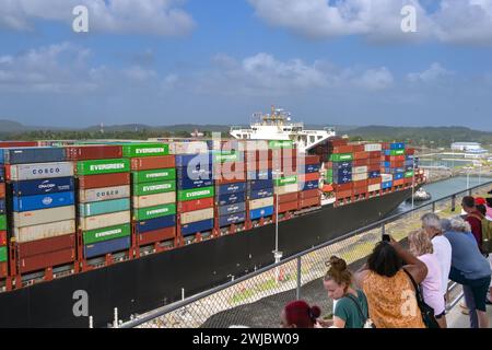 Colon, Panama - 22. Januar 2024: Menschen auf der Aussichtsplattform des Besucherzentrums beobachten, wie ein Containerschiff durch die Schleusen der Agua Clara fährt Stockfoto