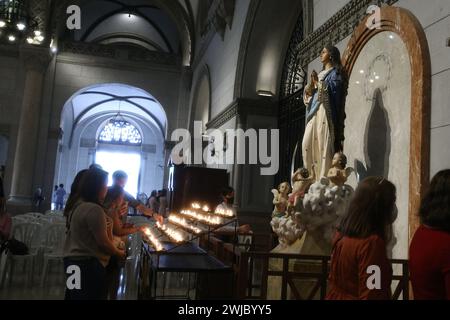 Manila, Philippinen. Februar 2024. Mehrere Gläubige zünden Votivkerzen an und beten während einer Aschermittwochs-Messe in der Manila Cathedral in Manila, Philippinen am 14. Februar 2024. (Foto: Dennis Jerome Acosta/Pacific Press/SIPA USA) Credit: SIPA USA/Alamy Live News Stockfoto