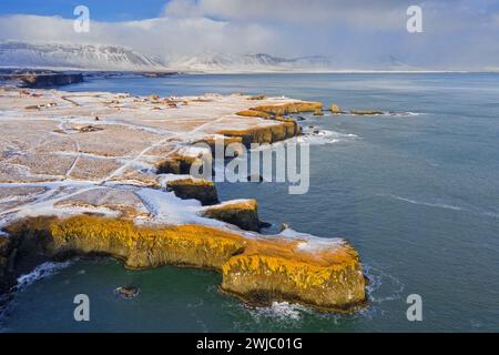 Blick aus der Vogelperspektive über die vulkanische Basaltklippe in der Nähe von Arnarstapi auf der Südseite der Halbinsel Snæfellsnes im Winter, Western Region, Island Stockfoto