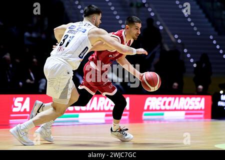 Torino, Italien. Februar 2024. EA7 Emporio Armani Milano DIEGO FLACCADORI fährt in den Korb, während Aquila Basket Trento Matt Mooney beim Viertelfinalspiel der Frecciarossa Final Acht zwischen EA7 Emporio Armani Milano und Dolomiti Energia Trentino in Turin Norditalien am Mittwoch, 14. FEBRUAR 2024 verfolgt wird. Sport. (Foto: Marco Alpozzi/Lapresse) Credit: LaPresse/Alamy Live News Stockfoto