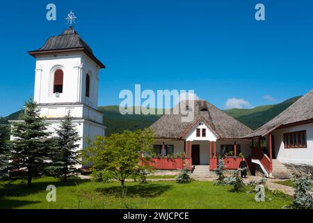 Orthodoxe Kirche mit weißem Turm und grauem Dach vor einem Bergpanorama unter blauem Himmel, Rumänisch-orthodoxes Kloster Cheia, Maneciu Stockfoto